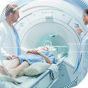 Cardiac imaging Patient lying on an MRI machine table while two doctors operate the machine