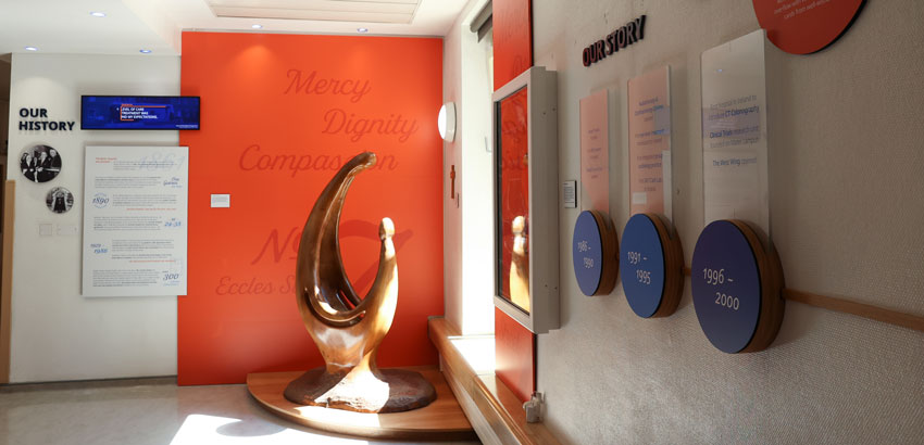 our-network An interior hospital hallway in Mater Private Network in Dublin which has a large ornament and a storyboard on the walls.