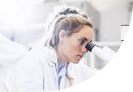 A female medical professional looking through a microscope.