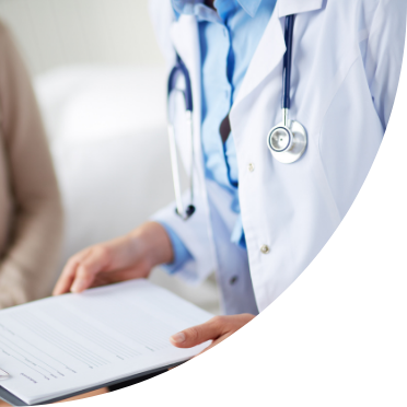 A doctor sitting down holding a clipboard.