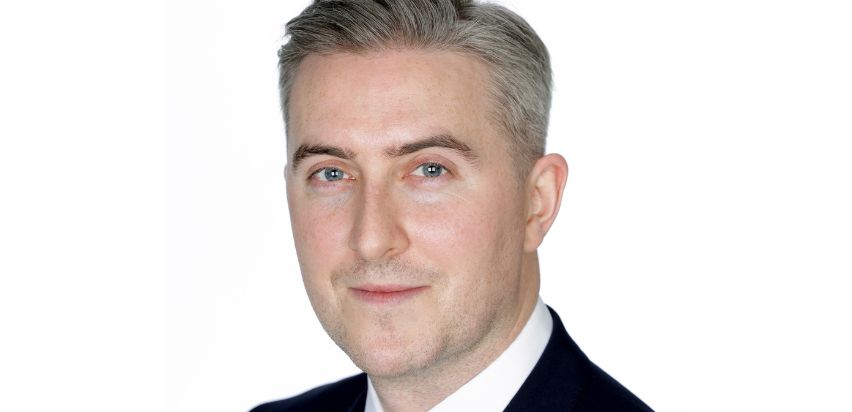 Dr. JJ Coughlan, grey hair, wears a suit