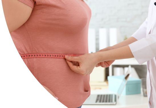 A medical professional measuring a patient's waist circumference.