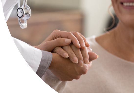 Close-up of a doctor holding a patient's hand.