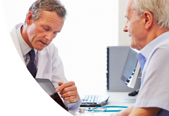 Doctor discussing medical information on a tablet with an elderly patient in a clinic